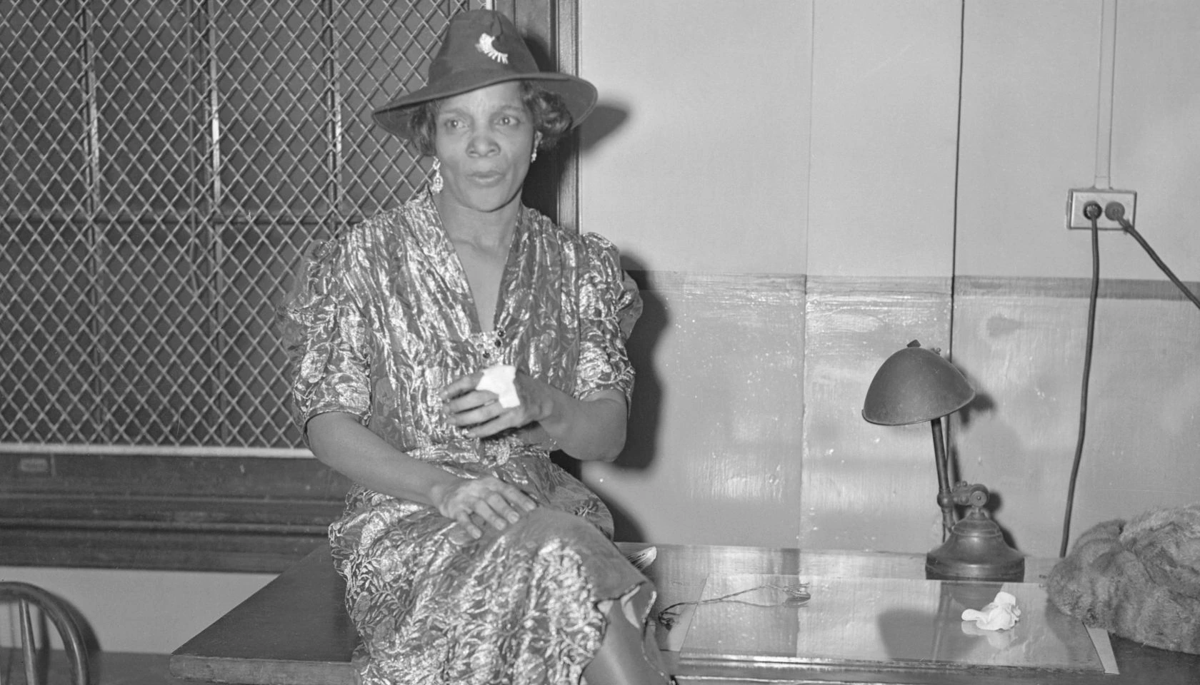 Black-and-white portrait of Stephanie St. Clair seated in a patterned dress and hat.